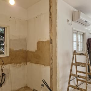 חדר בשיפוץ עם סולם וקירות חשופים