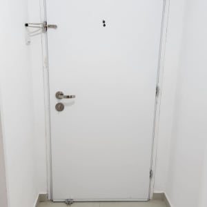 דלת לבנה עם מנעול ובריח מתכת