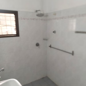 חדר אמבטיה עם מקלחת, כיור ומתקן מגבות