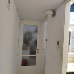 דלת זכוכית עם מסגרת לבנה במסדרון צר