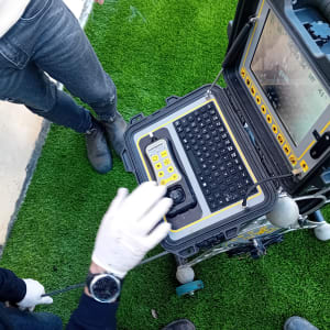 מכשיר איתור נזילות עם מסך ומקלדת על דשא