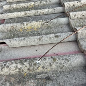 תקריב של גג רעפים עם חוטי מתכת חלודים