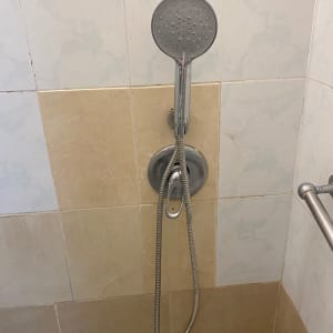 ראש מקלחת על קיר אריחים בחדר אמבטיה