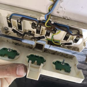 חוטי חשמל מחוברים לשקע פתוח על קיר