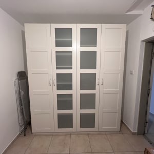 ארון בגדים לבן עם דלתות זכוכית בחדר