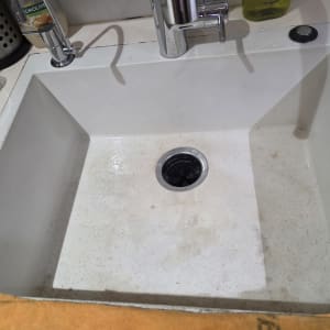 כיור מטבח בהתקנה אינטגרלית במשטח שיש עם ברז וטוחן אשפה