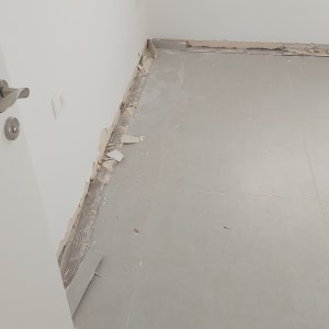 קיר עם תיקוני טיח ורצפה חשופה