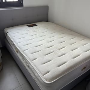 מזרן לבן על מיטה עם ראש מיטה אפור