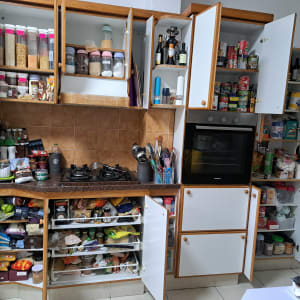 מטבח מאורגן עם ארונות פתוחים ומוצרי מזון מסודרים.