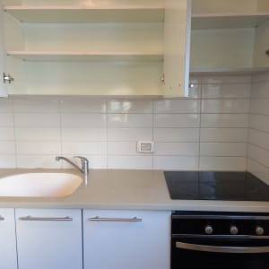 מטבח עם ארונות פתוחים, כיור וכיריים חשמליים