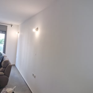 קיר צבוע בלבן עם תאורה עליונה