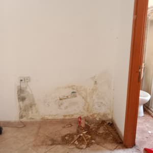 קיר עם סימני רטיבות ונזק, ללא אנשים או טקסט.