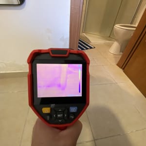 מצלמה תרמית בודקת נזילות על קיר חדר אמבטיה