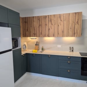 מטבח מודרני עם ארונות עץ, כיור ותנור אפייה