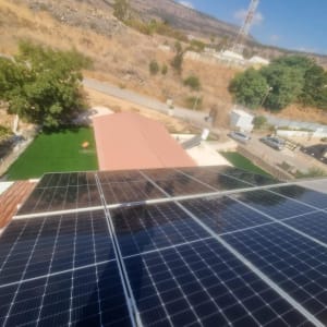 פאנלים סולאריים מותקנים על גג עם נוף הררי ברקע