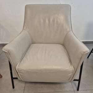 כורסה בהירה על רצפת אריחים אפורה