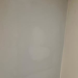 קיר גבס צבוע בגוון בהיר עם תאורה בפינה