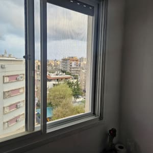 חלון אלומיניום עם נוף עירוני ברקע