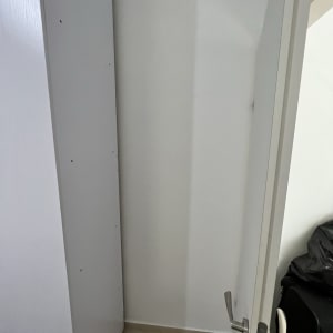 ארון לבן עם דלת פתוחה וחורים קטנים