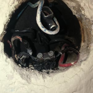 חוטי חשמל חשופים בתוך קיר עם חיבורים ישנים