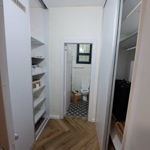 ארון מסודר ליד חדר שירותים עם רצפת פרקט