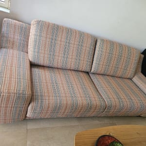 ספה מרופדת בצבעים חומים וכתומים בחדר מגורים