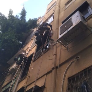 עובדים בגובה מתקנים מזגן על בניין