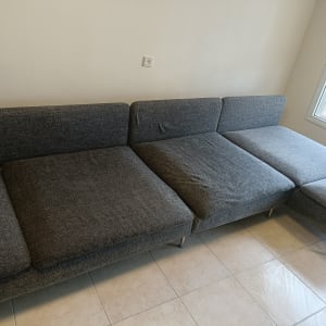 ספה אפורה על רצפת אריחים ליד חלון