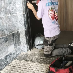 אדם מתקין מנעול בדלת עם מקדחה