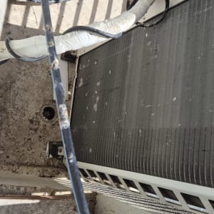 צינורות ומזגן על קיר חיצוני, ייתכן קשור להרחקת יונים.