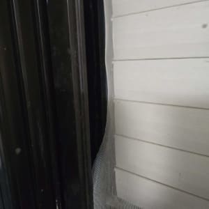 תריסים לבנים עם מסגרת שחורה ורשת קרועה