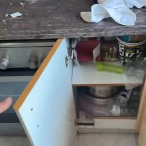 מטבח עם דלת ארון פתוחה וכלים על השיש