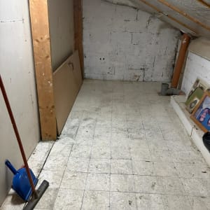 חדר ריק עם רצפת אריחים וכלי ניקוי בפינה