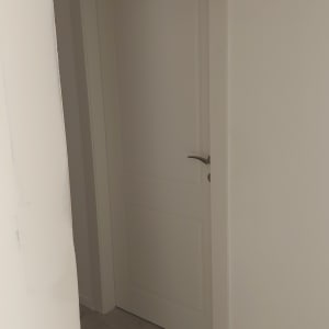 דלת לבנה עם ידית מתכת בחדר פנימי