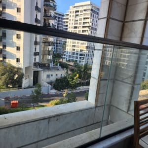 מעקה זכוכית במרפסת עם נוף לבניינים