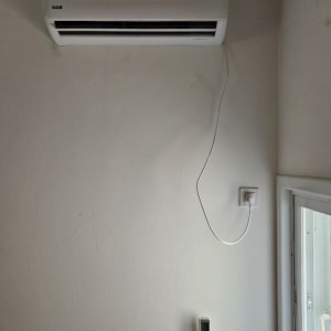 מזגן מותקן על קיר עם תצוגת טמפרטורה 22 מעלות