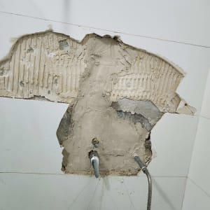 תמונה של קיר עם תיקון צנרת חשופה