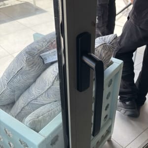 ידית אלומיניום על דלת זכוכית עם כריות ברקע