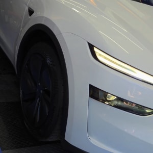 רכב לבן על רצפת מוסך עם תאורה חזקה