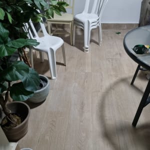 רצפת עץ חדשה עם כיסאות פלסטיק לבנים