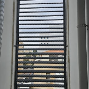 רשת מתכת על חלון למניעת כניסת יונים