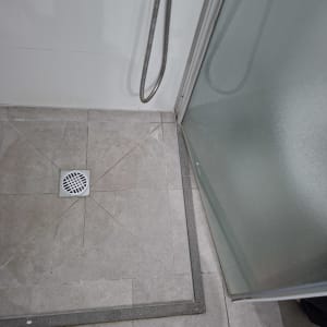 רצפת מקלחת עם ניקוז ודלת זכוכית