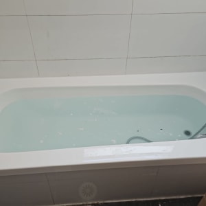 אמבטיה עם מים, ברז ומקלחת יד