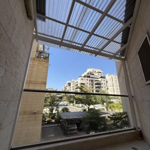 מרפסת עם גג שקוף ונוף לבניינים