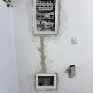 לוח חשמל מותקן על קיר עם חוטים וצינורות חשמל