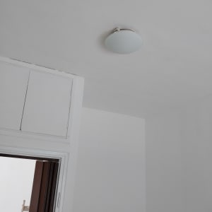 תקרה צבועה בלבן עם מנורה עגולה