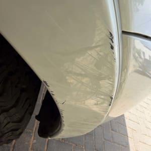 שריטות על פגוש רכב לבן בחניה