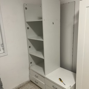 ארון לבן עם מדפים ומגירות, מברג על הרצפה