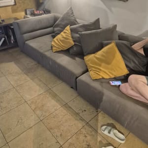 ספה אפורה עם כריות צהובות בחדר מגורים