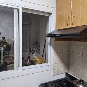 חלון אלומיניום במטבח עם כיריים וארון עץ